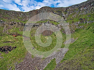 Colonnades of columnar jointing in basalt with fallen scree below at Giant`s Causeway on the Antrim Coast of Northern Ireland, UK