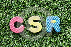 Color alphabet letter in word CSR Abbbreviation of corporate social responsibility on green grass background