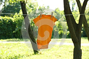 Color baby onesie hanging on clothes line