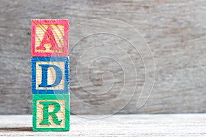 Color block in word ADR Abbreviation of adverse drug reaction on wood background