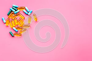 Color capsules. Medicine pills on pink background top view copy space