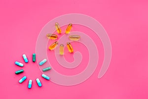 Color capsules. Medicine pills on pink background top view copy space. Fireworks of flower sign