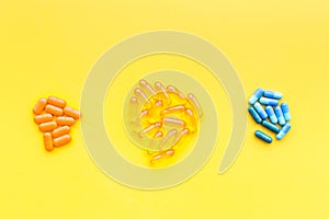 Color capsules. Medicine pills on yellow background top view copy space