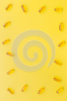 Color capsules. Medicine pills on yellow background top view copy space pattern