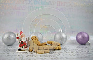 Color Christmas food photography gingerbread man santa claus and silver purple tree baubles on xmas wrapping paper background