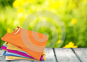 Stack of colorful t-shirts on wooden table with