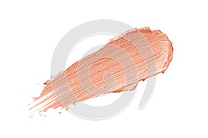 Color corrector stroke isolated on white background. Peach pink color correcting cream concealer photo