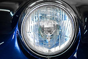 Color detail on the headlight of a vintage car.