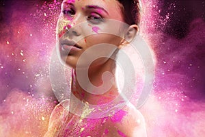 Color fantasy. Conceptual shot of a beautiful young woman covered in multi-colored powder paint.