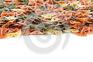Color Farfalle - dry pasta isolated on a white background. A variety of types and forms of Italian pasta. Closeup