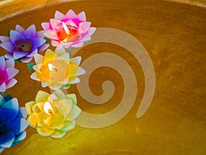 Color filtered: Candle in the flowers colorful holders floating on water, temple and mindfulness background concept