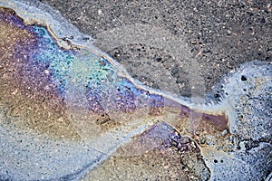 Color gasoline fuel spot on black asphalt, industrial pollution concept.