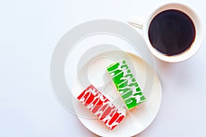 Color glazed cakes and coffee cup on white background.