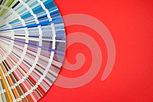 Color guide close up. Assortment of flowers for design. Color palette fan on red background A graphic designer selects colors from