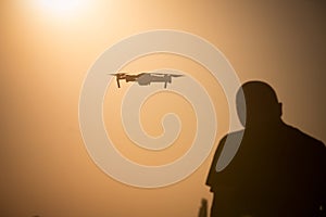 Man flying a drone at sunrise