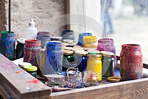 Color jars and tempera on working table in ceramic lab in turkey