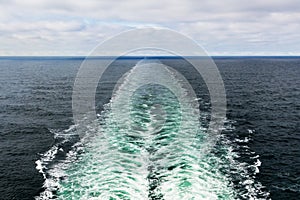 A color landscape photo of a cruise ship`s wake