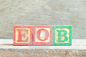 Color letter block in word EOB Abbreviation of end of business on wood background
