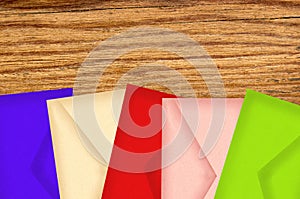 Color letters envelopes on wooden texture close-up