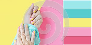 Color palette female hands in with a bright pink-yellow gradient manicure on a yellow-pink background.