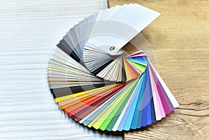 Color palette swatches. Palette of different colors and shades on wood background. Color catalog for tinting facade and interior