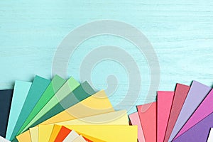 Color palettes on light blue wooden background. Space for text