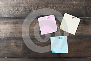 Color paper note with pin on old wood background