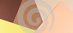 Color papers geometry composition background with yellow, beige and brown tones.