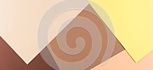 Color papers geometry composition background with yellow pink, beige and brown tones.