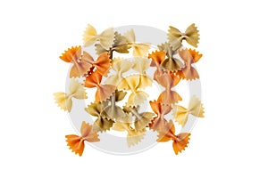 Color pasta in the form of bows. Raw farfalle with spinach and tomato isolated on a white background