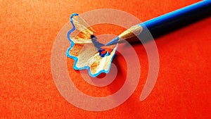color pencil with its shave isolated on orange background