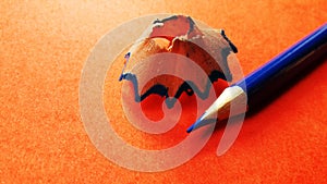 color pencil with its shave isolated on orange background