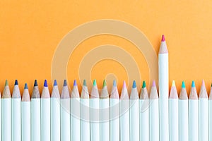 Color pencil in row with stand out pink one using as individual creativity, leadership or feminine and woman leader idea