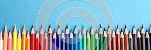 Color pencils on blue  background, flat lay with space for text. Banner design