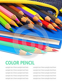 Color pencils and a blue note book isolated on white background