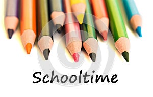 Color pencils isolated on white background. Text schooltime.