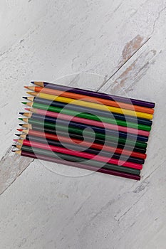 Color pencils lined up on a neutral wooden background