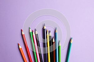 Color pencils lying on pastel purple background. Back to school concept. Colorful art studying and painting process. Drawing with