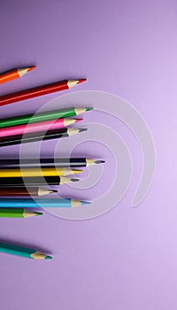 Color pencils lying on pastel purple background. Back to school concept. Colorful art studying and painting process. Drawing with