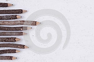 Color pencils made of nature wood on white grunge wooden table,