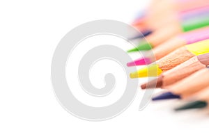 Color pencils in a row close up macro shot on white background