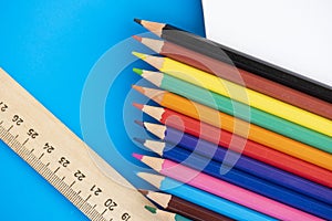 Color pencils, ruler and notepad, on the blue background.