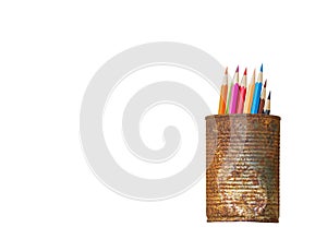 Color pencils in rusty tin can on white