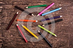 Color pencils scattered on wood background photo