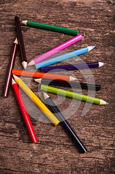 Color pencils scattered on wood background photo