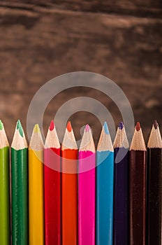 Color pencils scattered on wood background photo