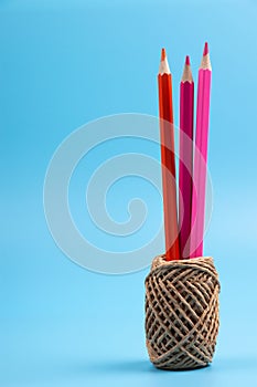 Color pencils and string basket on blue background