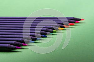 Color pencils of various color on a green background