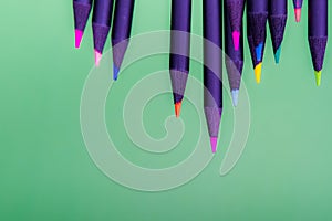 Color pencils of various color on a green background