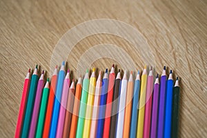 Color pencils on wooden background with copy space. Back to school and education concept.